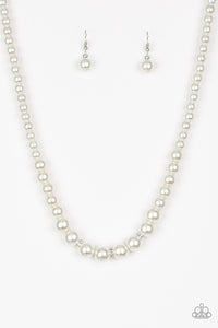 Gradually increasing in size near the center, a strand of luminescent white pearls falls just below the collar. White rhinestone encrusted rings are sprinkled along the center for a timeless finish. Features an adjustable clasp closure.  Sold as one individual necklace. Includes one pair of matching earrings.