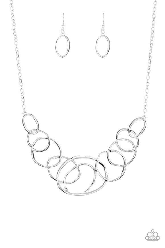 Featuring a subtle hammered finish, a collection of asymmetrical silver rings join into a stationary pendant below the collar for a bold look. Features an adjustable clasp closure.