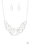 Featuring a subtle hammered finish, a collection of asymmetrical silver rings join into a stationary pendant below the collar for a bold look. Features an adjustable clasp closure.
