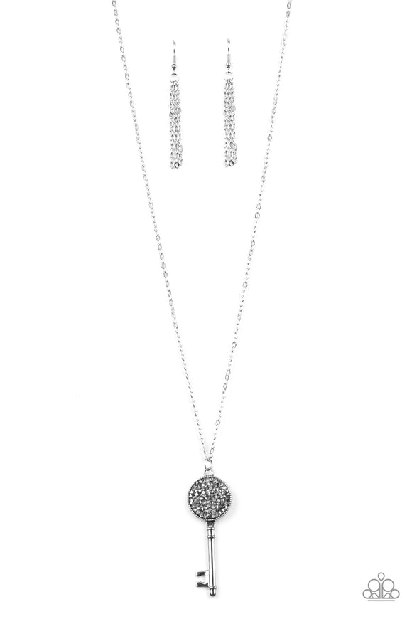 Encrusted in smoky and glittery hematite rhinestones, a sparkling silver key swings from the bottom of a lengthened silver chain for a whimsical look. Features an adjustable clasp cl