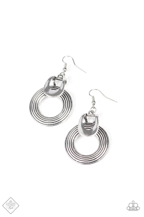 Grooved with antiqued shimmer, an abstract silver hoop attaches to a bent silver fitting for an artisan inspired look. Earring attaches to a standard fishhook fitting.
