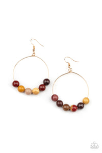 An oversized collection of earthy stones slide along the bottom of a dainty gold hoop, creating an earthy centerpiece. Earring attaches to a standard fishhook fitting