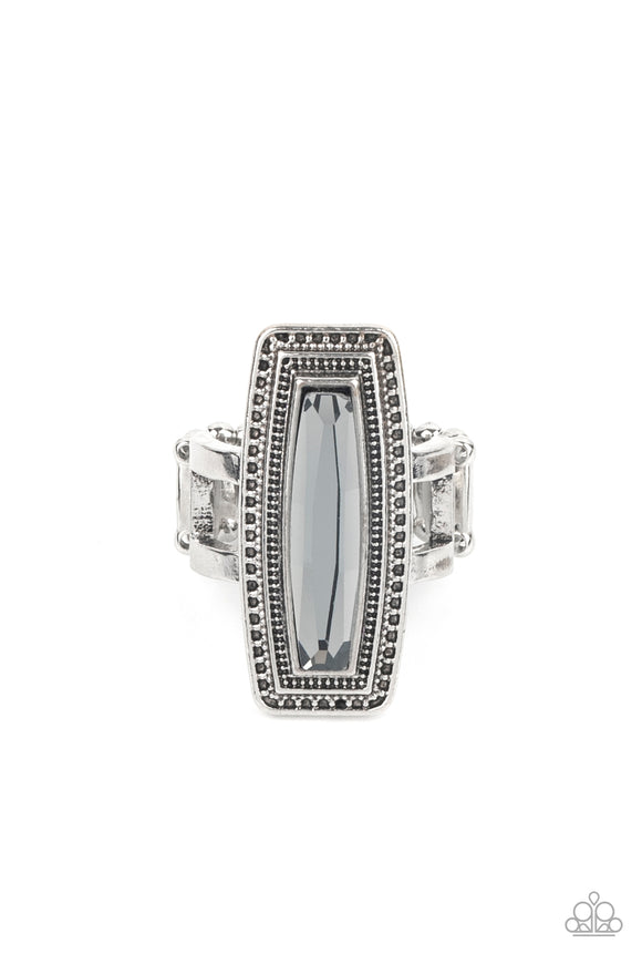 An elongated smoky gem is pressed into the center of a studded silver frame atop layered silver bands, creating a stellar centerpiece atop the finger. Features a stretchy band for a flexible fit.