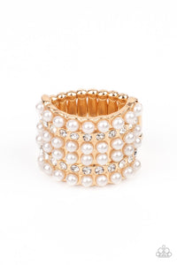 Dainty rows of bubbly pearls and glassy white rhinestones alternate across the front of a thick gold band, creating a vintage inspired statement piece. Features a stretchy band for a flexible fit.