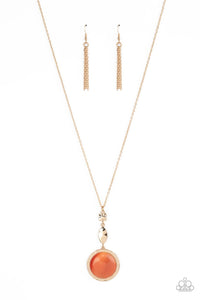 Encased in a hammered gold frame, an oversized orange cat's eye stone pendant swings from the bottom of hammered square and marquise shaped frames that are suspended from an extended gold chain, resulting in a magical centerpiece. Features an adjustable clasp closure.