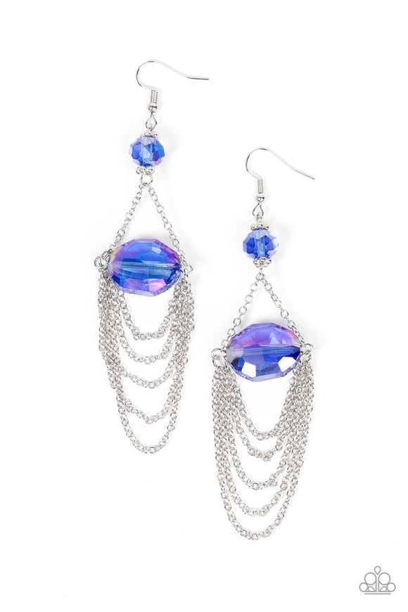Tiers of dainty silver chains delicately layer from an oversized oval iridescent blue gem that is suspended from a faceted matching blue crystal-like bead, resulting in an ethereal chandelier. Earring attaches to a standard fishhook fitting.