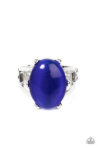 An oval blue cat's eye gemstone sits atop a pronged silver frame along two layered silver bands, resulting in an enchanting centerpiece atop the finger. Features a stretchy band for a flexible fit.