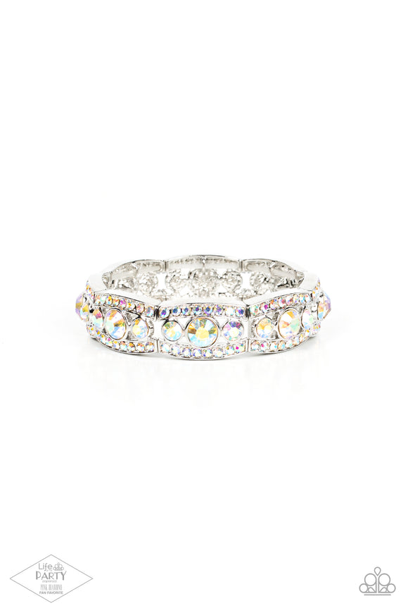 Iridescent rhinestone encrusted silver bars flank a dazzling trio of oversized iridescent rhinestones, coalescing into a glittery frame. The sparkly frames are threaded along stretchy bands around the wrist, creating an irresistible shimmer.