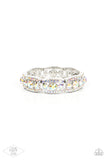 Iridescent rhinestone encrusted silver bars flank a dazzling trio of oversized iridescent rhinestones, coalescing into a glittery frame. The sparkly frames are threaded along stretchy bands around the wrist, creating an irresistible shimmer.
