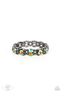 A row of exaggerated oil spill rhinestones is threaded along stretchy bands and wraps boldly around the wrist. Dainty gunmetal beads separate each rhinestone, adding a metallic grit to the piece.