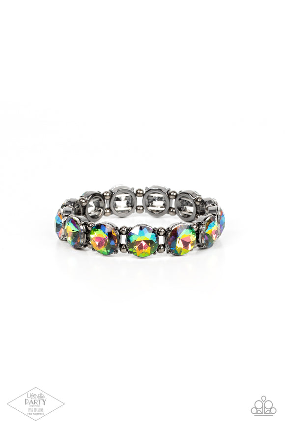 A row of exaggerated oil spill rhinestones is threaded along stretchy bands and wraps boldly around the wrist. Dainty gunmetal beads separate each rhinestone, adding a metallic grit to the piece.