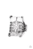 A white rhinestone dotted star twinkles behind a glassy pane that seemingly floats atop the pronged frame, resulting in a stellar statement piece. Features a stretchy band for a flexible fit.