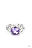 An oversized purple gem is nestled between silver prongs atop a band swirling with silver ribbons and dotted with dainty opal rhinestones, resulting in a stellar sparkle atop the finger. Features a dainty stretchy band for a flexible fit.