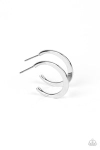 A deceptively simple hoop of silver smoothly curves around the ear. The flattened surface of the hoop catches the light, emitting radiant shimmer from the crescent-shaped curves. Earring attaches to a standard post fitting. Hoop measures approximately 3/4" in diameter.