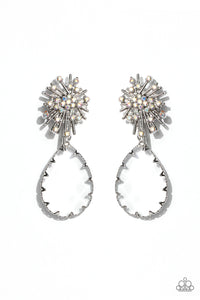 An explosion of radiating silver bars is topped with a sprinkle of iridescent rhinestones, creating a stellar anchoring point. Swinging below the starburst, an oversized, clear teardrop with a light-catching, faceted surface is wrapped in a textured border of silver, adding stunning dimension and refinement to the cosmic combination. Earring attaches to a standard post fitting. Due to its prismatic palette, color may vary.   Featured inside The Preview at Made for More! Sold as one pair of post earrings.