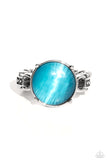 Pronged in a dainty silver fitting, a blue round cat's eye stone glimmers on an airy silver band dotted with textile textures for a pop of earthy color atop the finger. Features a dainty stretchy band for a flexible fit.  Sold as one individual ring.